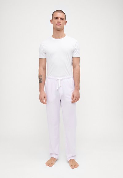 Camiseta blanca de manga corta y pantalones de chándal lilas claros con cintura con cordón, que presentan una tela suave y un ajuste relajado.