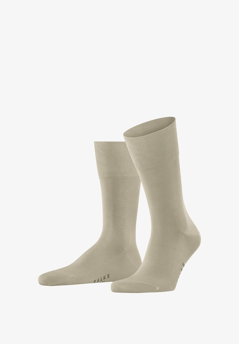 Calzini alla caviglia beige realizzati in materiale morbido ed elastico, con polsini a costine e una superficie liscia, con il nome del marchio "FALKE" sul lato.