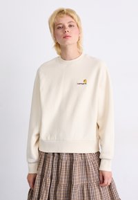 Krämlik sweatshirt tillverkad av mjuk tyg, med rund hals och ribbade ärmar. Broderad logotyp på bröstet ger detalj.