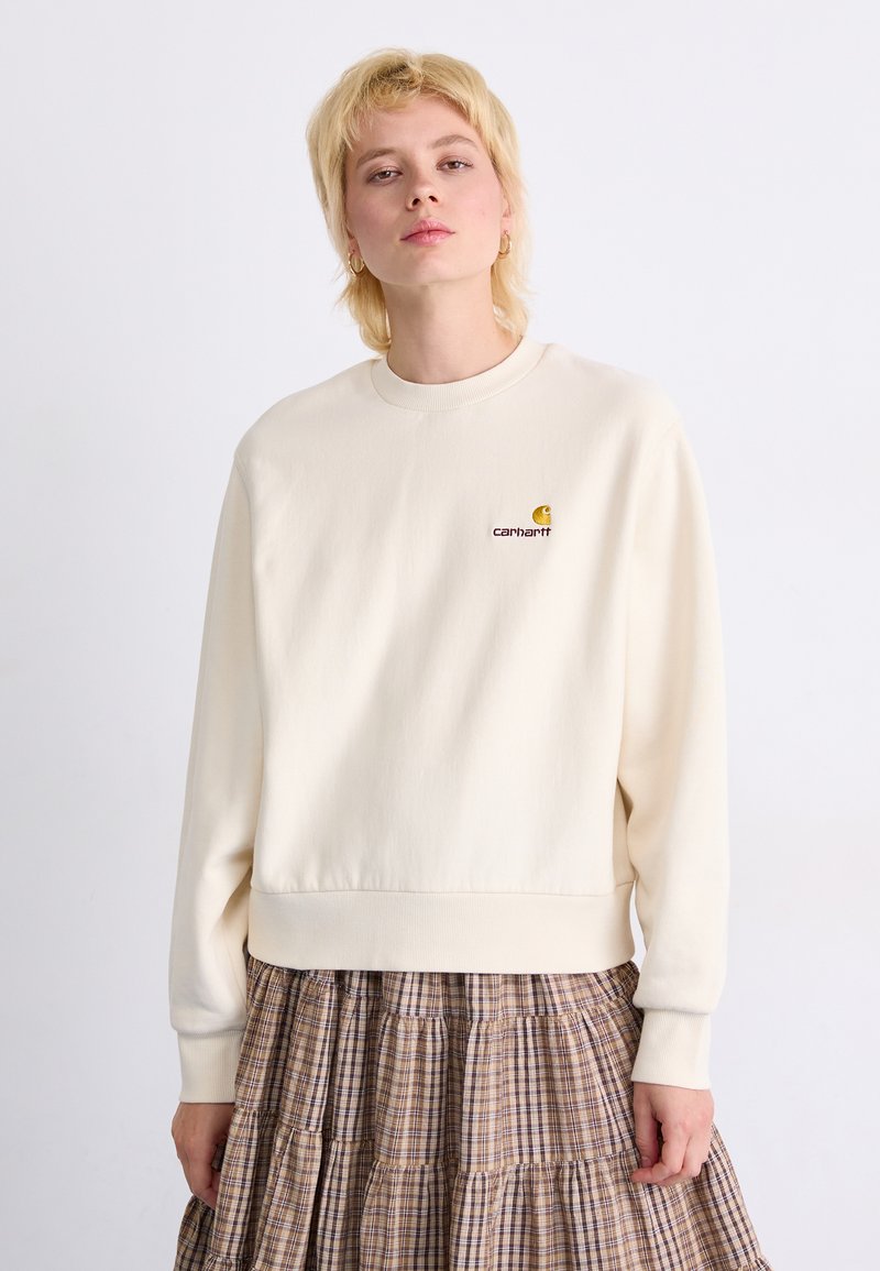 Krämlik sweatshirt tillverkad av mjuk tyg, med rund hals och ribbade ärmar. Broderad logotyp på bröstet ger detalj.