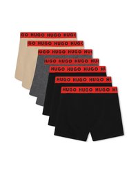 Έξι ζευγάρια αντρικών μποξεράκια σε μπεζ, γκρι και μαύρο, το καθένα με κόκκινες ζώνες μέσης που φέρουν μαύρο κείμενο "HUGO".