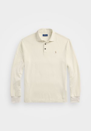 Ilgām piedurknēm polo krekls off-white krāsā, izgatavots no mīksta kokvilnas. Tajā ir saliekamais apkakle, trīs pogu plāksne un mazs izšūts logo.