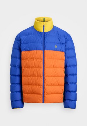 Pūdera jaka ar zilu augšējo daļu, oranžu apakšējo daļu un dzeltenu apkakli. Izstrādāta ar quilted struktūru un priekšējo rāvējslēdzēju.