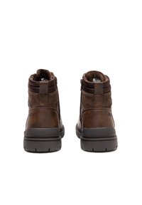 Brązowe botki za kostkę, wykonane z połączenia gładkiej i teksturowanej skóry, z tylnym zamkiem błyskawicznym oraz solidną gumową podeszwą. Projekt podkreśla funkcjonalność.