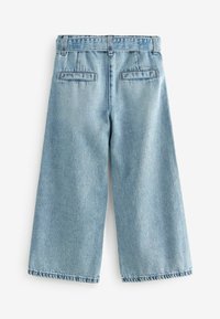 Ljusblå vida jeans i denim. Har två bakfickor, hög midja och synlig sömnad längs sömmarna.