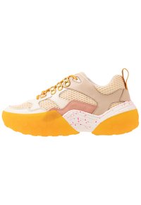 Creme- und beige Sneaker mit einem Mesh-Obermaterial, goldenen Beschlägen, rosa Akzenten und einer texturierten gelben Sohle mit rosa Sprenkeln.