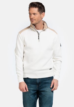 Witte rits-pullover met beige schouderaccenten, ribgebreide manchetten en zoom. Beschikt over een hoge kraag en zwarte ritsdetails.
