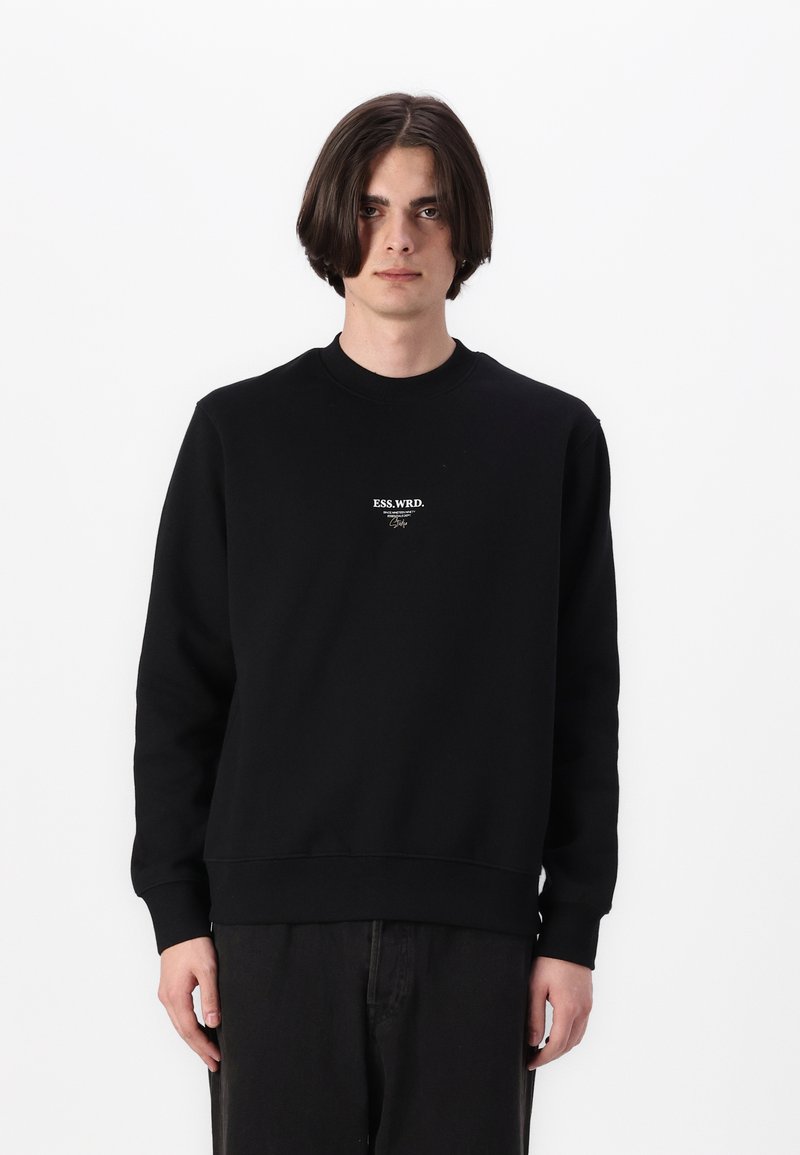 Black sweatshirt with a crew neckline, ribbed cuffs, and hem. Features white logo text on the chest. Soft cotton blend material.
