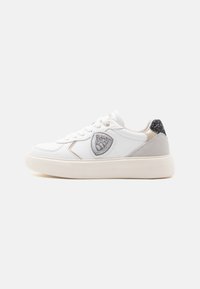 Sneaker bianco in pelle con accenti argentati testurizzati, punta rotonda e suola imbottita. Presenta un emblema decorativo a forma di scudo sul lato.