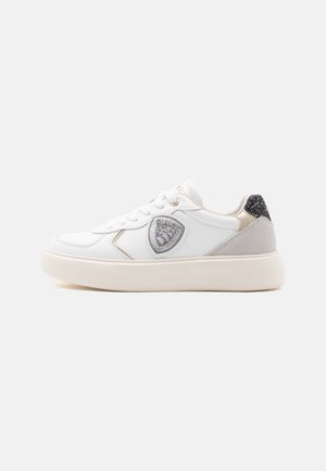 Sneaker bianco in pelle con accenti argentati testurizzati, punta rotonda e suola imbottita. Presenta un emblema decorativo a forma di scudo sul lato.