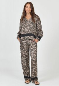 Luipaardprint loungewear set in zachte stof; bevat een losvallende top met een zwarte band aan de onderkant en bijpassende broek met een vergelijkbaar ontwerp.