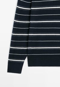 Donkerblauwe trui met horizontale witte en lichtgrijze strepen, lange mouwen en een geribbelde boord. Gemaakt van een zachte, gebreide stof.