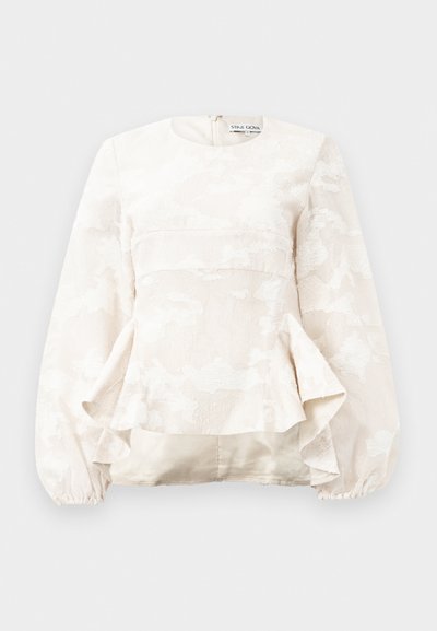 Lichtbeige blouse met een textuurpatroon van bloemen, ronde halslijn, lange pofmouwen en peplumstijl bij de taille. Ritsluiting aan de achterkant.