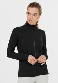 Zwarte sportjack met hoge kraag, ritssluiting aan de voorkant, lange mouwen en een strak ontwerp. Glad, rekbaar materiaal zonder zichtbare patronen.