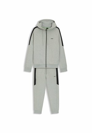 Completo felpa grigia e pantaloni della tuta con dettagli neri, tessuto morbido, chiusura con zip, cappuccio regolabile con cordoncino e logo sul petto e sulla gamba.