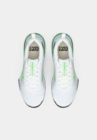 Hvite sportsko med grønne detaljer, nett-overdel og Air Max-merke. Har en rund tå, flate lisser og polstret krage.