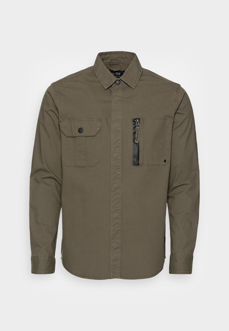 Chemise vert olive à manches longues avec col boutonné, poche à rabat sur la poitrine gauche et poche zippée sur la poitrine droite.