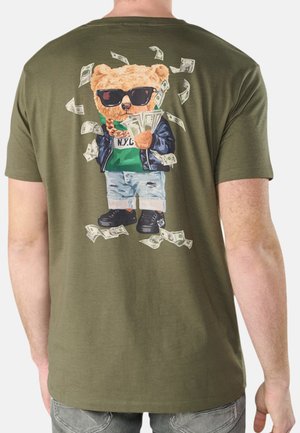 Camiseta de manga corta verde oliva con un gráfico de un oso con gafas de sol, sosteniendo dinero, con un diseño de chaqueta de cuero negra y pantalones cortos azules.