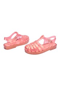 Pink translucent sandals with a woven design, adjustable buckle, and textured brown sole. The upper features cutouts for ventilation.