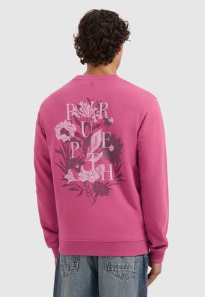 Roze sweatshirt met een bloemenontwerp op de achterkant. Ribbelachtige halslijn en manchetten; zachte textuur, casual pasvorm en ronde zoom.