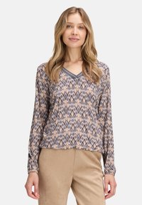 Long-sleeve blouse with a V-neck, featuring a geometric pattern in browns and blues, made of lightweight fabric, with gathered sleeves.