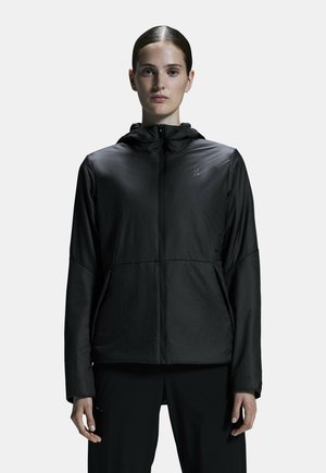 Schwarze leichte Jacke mit Frontreißverschluss, abnehmbarer Kapuze und zwei seitlichen Taschen. Hat eine glatte Textur und ein dezentes Logo auf der Brust.
