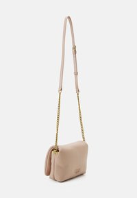 Borsa a tracolla in pelle rosa chiaro con catena dorata, caratterizzata da un design pieghevole e un delicato dettaglio del logo sul davanti.