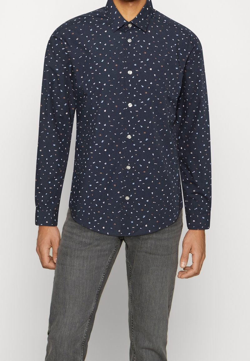 Langarmshirt in marineblauw met een verspreid klein patroon in lichtblauw, bruin en wit. Heeft een button-down kraag en een slim fit.