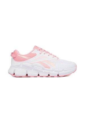 Zapatilla deportiva blanca y rosa claro con parte superior de malla, suela texturizada y lengüeta en el talón, mostrada de lado sobre un fondo blanco.