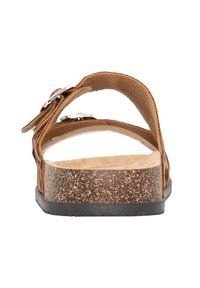 Sandale en cuir marron avec semelle en liège, sangle arrière et accents en métal argenté. Texture lisse, design ouvert avec ajustement réglable.