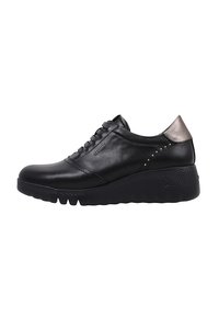 Sneaker en cuir noir avec un bout arrondi, un design à lacets, un accent métallique au talon et une semelle texturée avec de petites clous sur le côté.