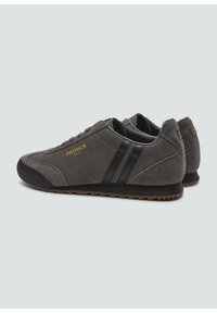 Zapatillas de ante gris con acentos en negro y dos franjas laterales. Cuentan con una suela de goma y un logo grabado en el lateral. Diseño clásico.