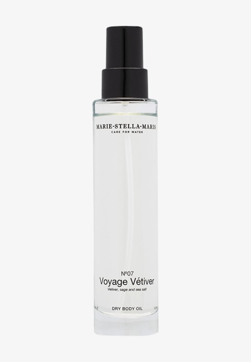 Klar glasflaska med svart pumpspets. Etiketten visar "Voyage Vétiver" och listar vetiver, salvia och havssalt. Kapacitet 100 ml.