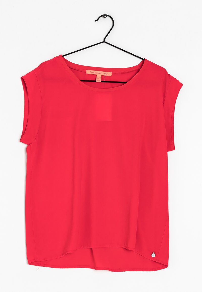 Blouse rouge à manches courtes avec encolure ronde suspendue sur un cintre noir contre un fond blanc.