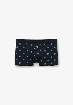 Schwarze Boxershorts mit kleinen blau-grünen Schildkrötenmustern, gleichmäßig über den Stoff verteilt, flach auf weißem Hintergrund.