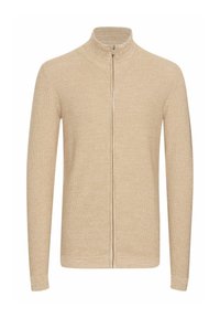 Suéter beige con cremallera, tejido de punto texturizado, cuello alto, mangas largas, diseño ajustado. Cierre frontal con cremallera, estilo minimalista.