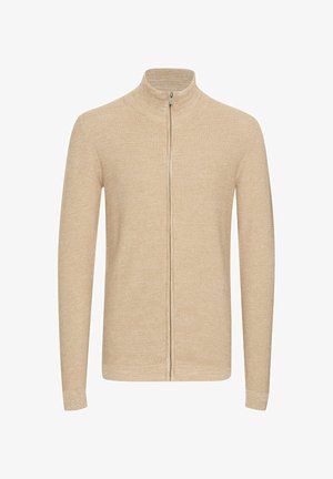 Beige zip-up genser, teksturert strikket stoff, høy krage, lange ermer, figursydde design. Front glidelås lukking, minimalistisk stil.