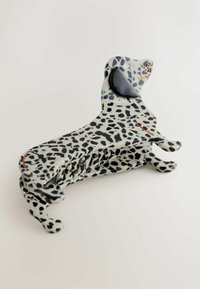 Plastikhårklämma formad som en dalmatinerhund, med ett prickigt svart och vitt mönster, en glansig yta och överdimensionerade öron.
