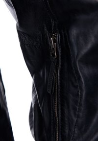 Zwarte leren jas met een gedetailleerde rits, een soepele textuur en een op maat gemaakte pasvorm, zichtbaar in de close-up weergave van de zijnaad.