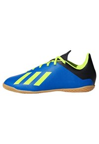 Blue athletic shoes with a textured fabric upper, neon yellow accents, black heel, and gum rubber sole. Three diagonal stripes featured.