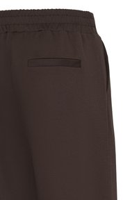 Gros plan sur un pantalon marron foncé doté d'une taille élastique et d'une poche passepoilée à l'arrière.