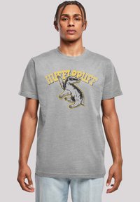 Pilkas medvilnės marškinėliai su juoda ir geltona grafiką, vaizduojančia želė (šakotąjį lokį), ir užrašu "HUFFLEPUFF" viršuje kupro pavidalu. Trumpomis rankovėmis ir apvalia kaklo iškirpte.