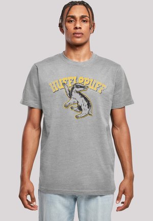 Pilkas medvilnės marškinėliai su juoda ir geltona grafiką, vaizduojančia želė (šakotąjį lokį), ir užrašu "HUFFLEPUFF" viršuje kupro pavidalu. Trumpomis rankovėmis ir apvalia kaklo iškirpte.
