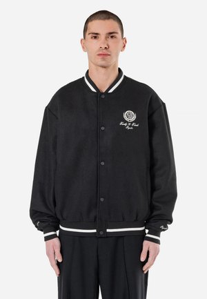 Zwarte varsityjack met witte gestreepte kraag en manchetten, knoopsluiting en geborduurde details op de borst. Zacht, textuurgegeven stof.
