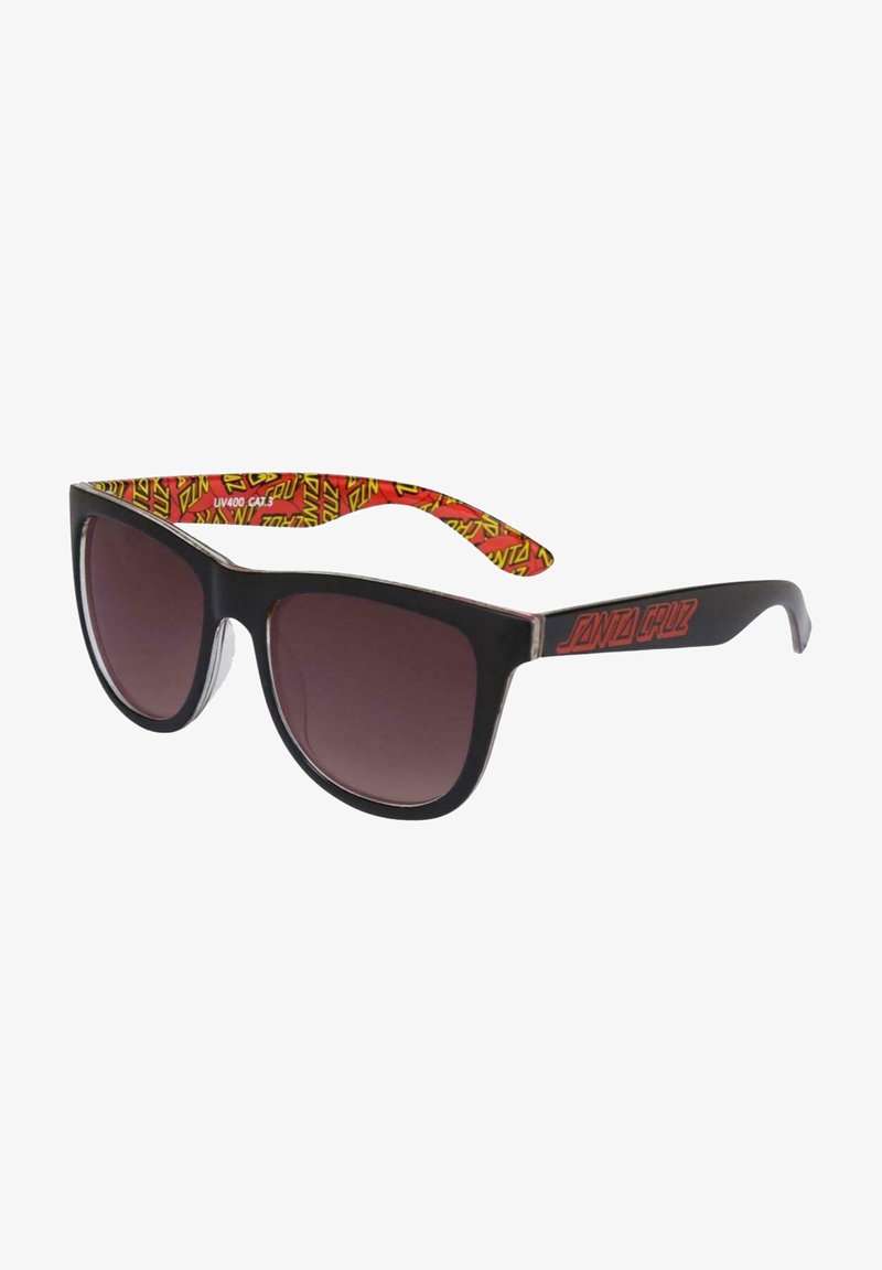 Óculos de sol pretos com lentes em degradê e um design geométrico nos braços das hastes com padrão em vermelho e amarelo. Apresenta uma ousada marca "Santa Cruz".