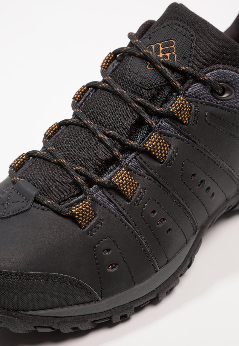 Czarny but sportowy z teksturowanej skóry i siateczki, z pomarańczowymi sznurowadłami, wyściełanym kołnierzem oraz trwałą gumową podeszwą z bieżnikiem.