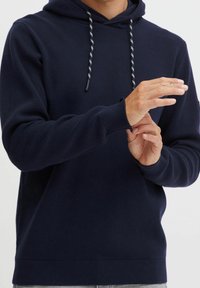 Sweatshirt à capuche bleu marine en mélange de coton, doté d'un cordon de serrage bicolore ajustable et de bords-côtes aux poignets et à l'ourlet. Texture lisse, design ajusté.