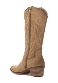 Bota vaquera de ante marrón con un tacón de altura media, que presenta costuras decorativas y una cremallera lateral para una fácil puesta. Diseño de puntera redondeada.