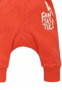 Oranje katoenen babybroekjes met een verlaagde kruisontwerp, voorzien van witte tekst "FANTASTISCH!" op het linkerpijpje en ribbeltjes aan de enkels.
