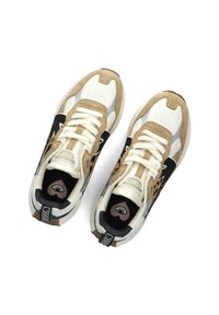 Scarpe da ginnastica beige e crema con pelle perforata, dettagli in suede, rifiniture nere e una soletta decorata con un motivo a cuore e arcobaleno.